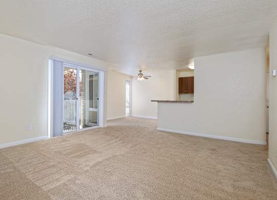 an empty living room with a door to a balcony