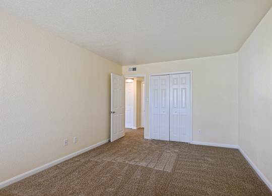 a spacious living room with carpeting and white walls