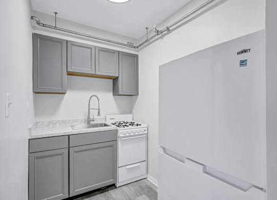 A kitchen with a white fridge and a white counter top.