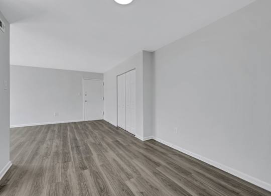 A room with wood flooring and white walls.