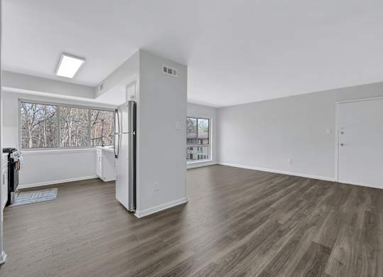 A spacious room with wooden floors and white walls.