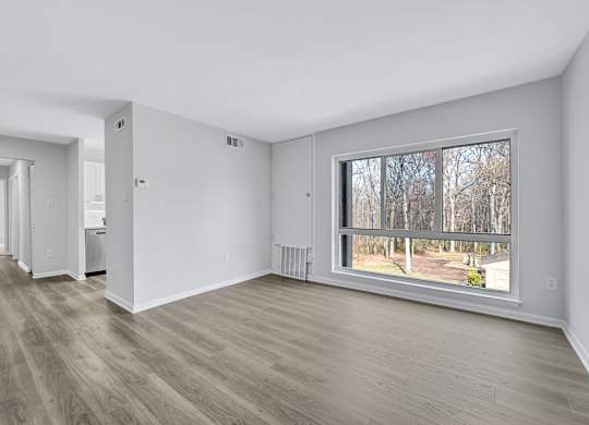 A room with a large window and a view of trees outside.