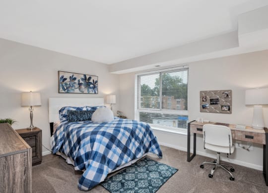 a bedroom with a bed and a desk with a chair
