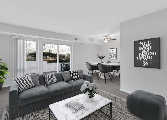 an open living room with a gray couch and a coffee table