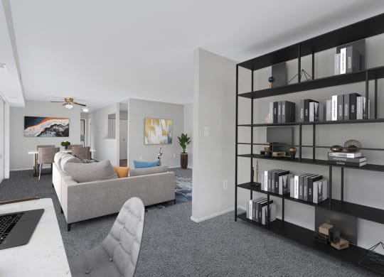 an open living room with a couch and a desk with a laptop