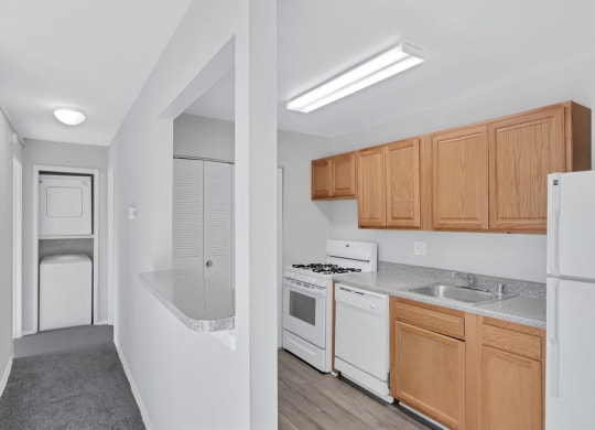 a kitchen with white appliances and wooden cabinets