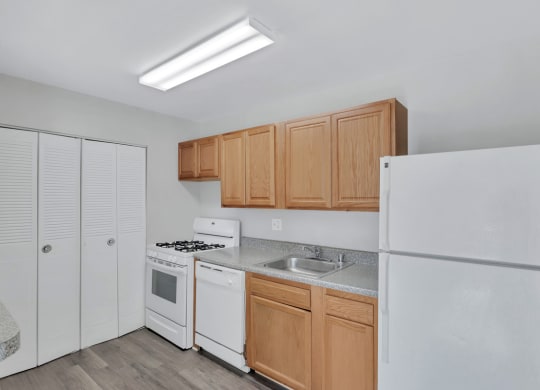 a kitchen with white appliances and wood cabinets