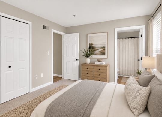 A bedroom with a large bed and a painting on the wall.