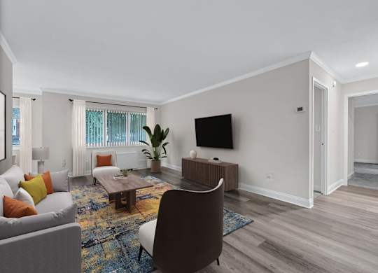 A living room with a grey couch, a brown chair, a wooden coffee table, a flat screen TV, and a rug.