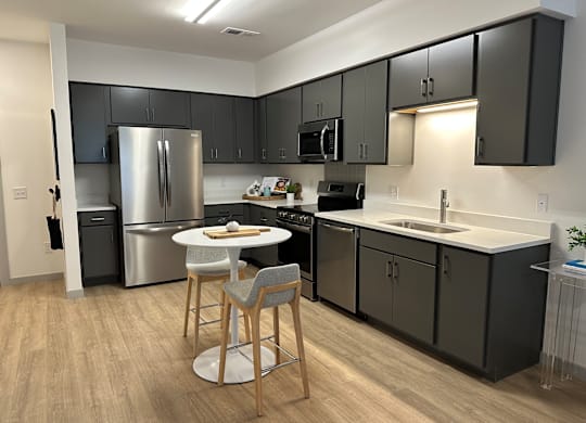 A kitchen with a table and chairs in the middle of it.