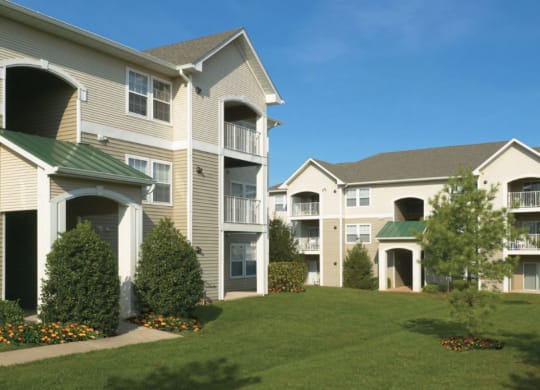 an exterior view of apartments with grass and trees