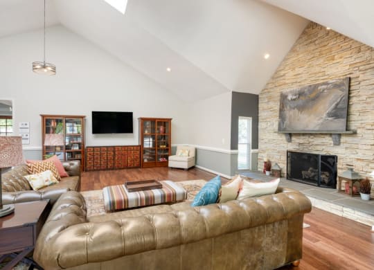 the living room has a fireplace and a large leather couch