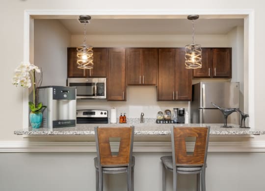 a kitchen with a counter top with two chairs