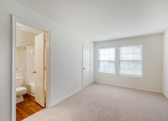 a bedroom with a toilet and a window   and a bathroom