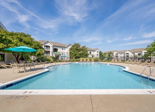 a swimming pool with apartment buildings in the background
