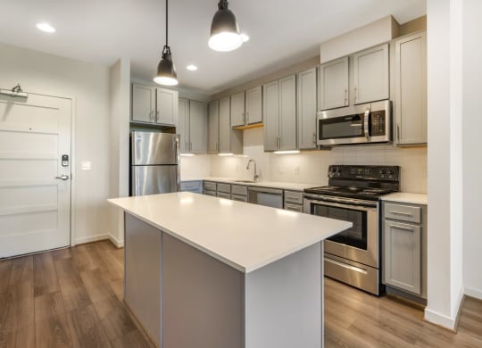 a renovated kitchen with a white island and stainless steel appliances
