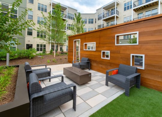 a backyard patio with chairs and a wooden shed