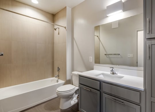a bathroom with a sink toilet and tub and a mirror