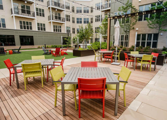 a large patio with tables and chairs and a building in the background