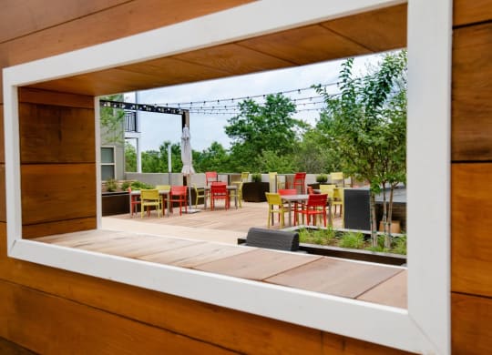a window view of a patio with tables and chairs