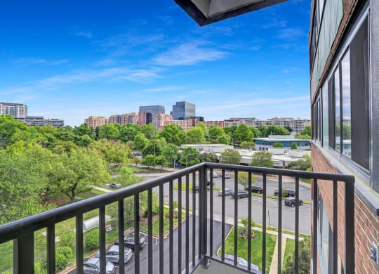 the view of the city from the balcony of an apartment building with a balcony railing