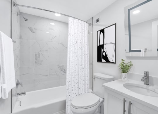 a white bathroom with a shower and a sink