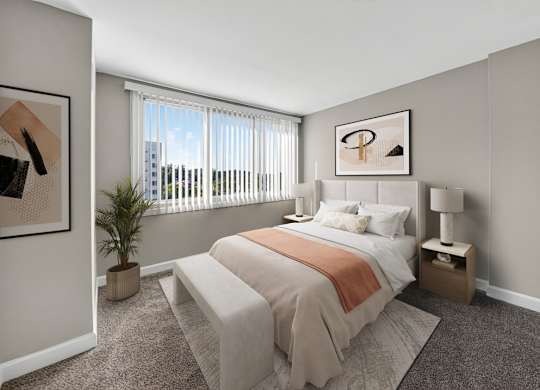 A bedroom with a bed, nightstand, and window.