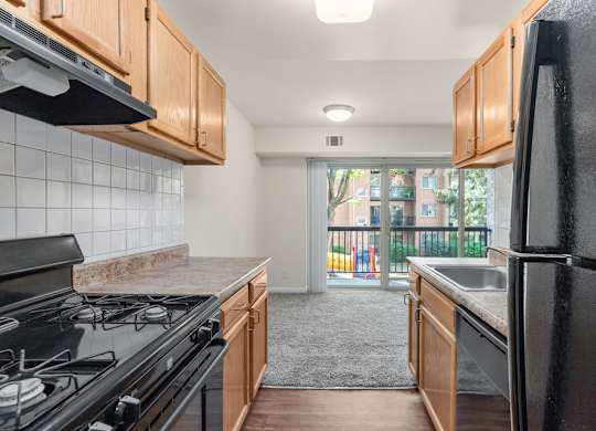 A kitchen with black appliances and wooden cabinets.