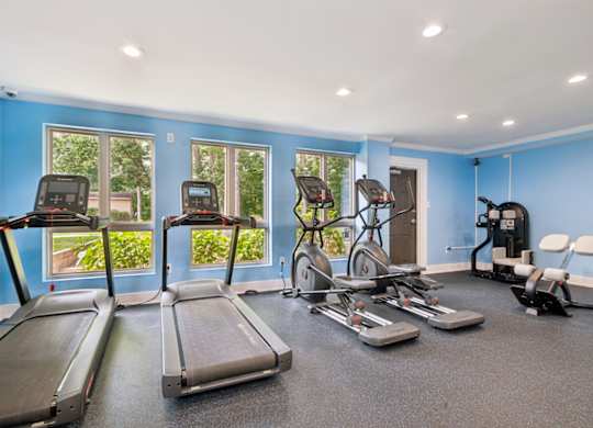 A spacious gym with treadmills, exercise bikes, and other equipment.