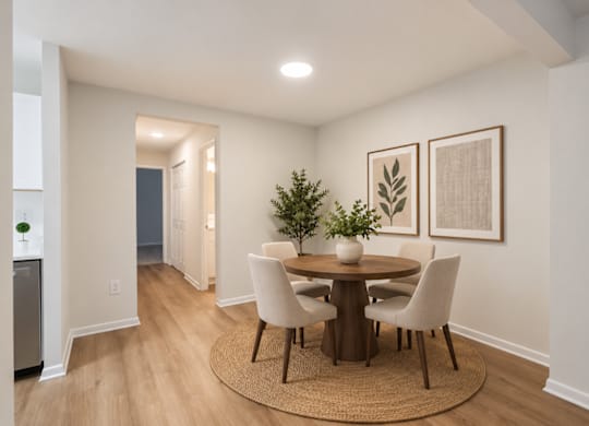 A dining room with a round table and chairs.