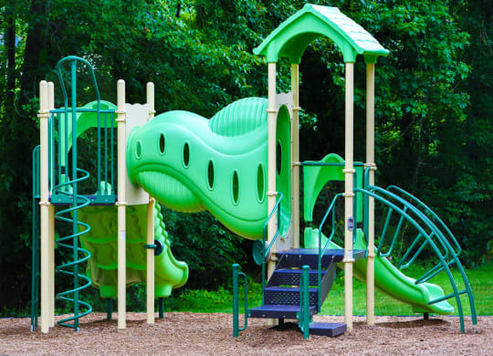 a playground with a large green dinosaur