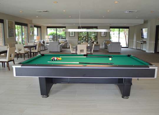 A pool table in a room with a green felt top.