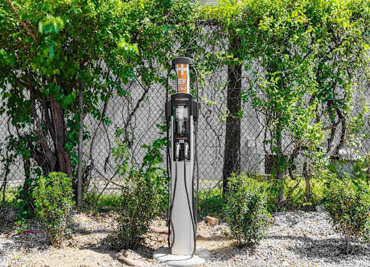 a gas pump sitting in front of a fence