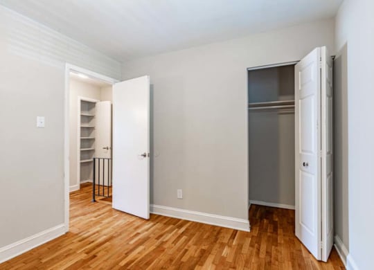 an empty room with two closets and a wood floor