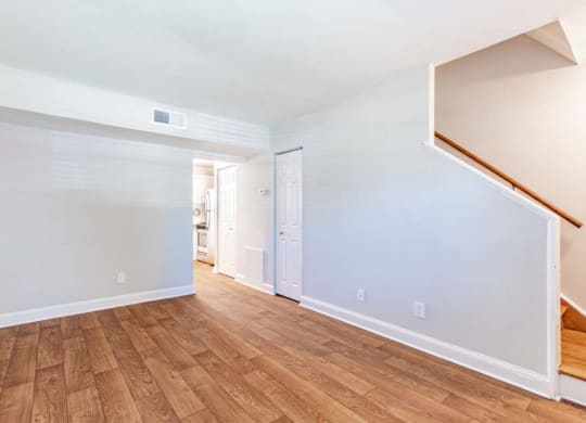 the living room and dining room of an empty house with wood flooring