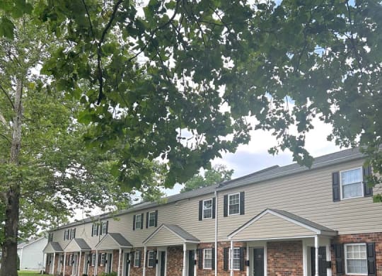 a row of houses on the side of a grass field