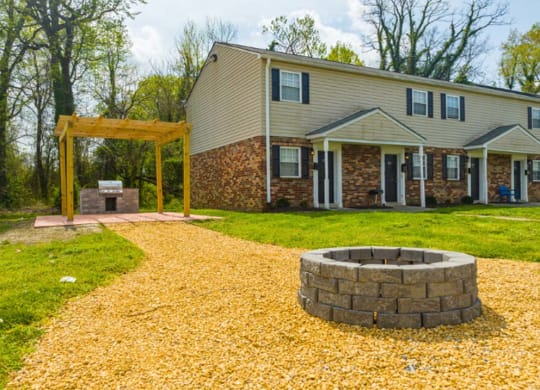a backyard with a fire pit and a house