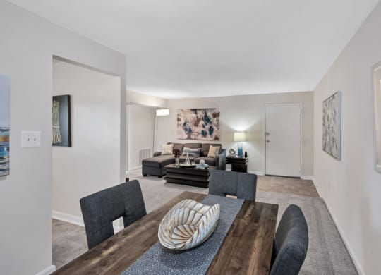 a living room with white walls and a wooden table and chairs