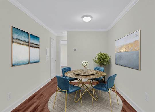 A dining room with a round table and blue chairs.