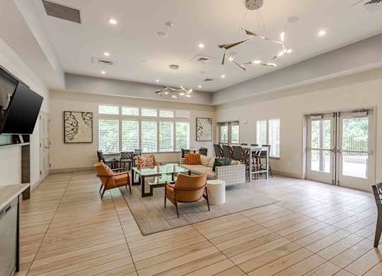 A spacious living room with a ceiling fan and large windows.
