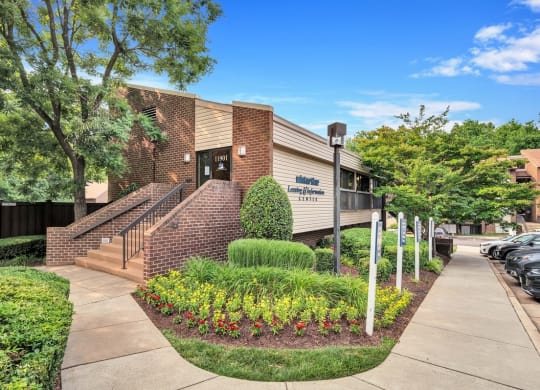 a brick building with a staircase and landscaping in front of it