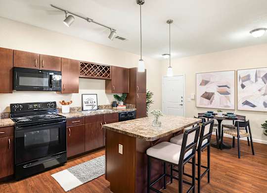 A kitchen with a black stove top oven and black microwave.