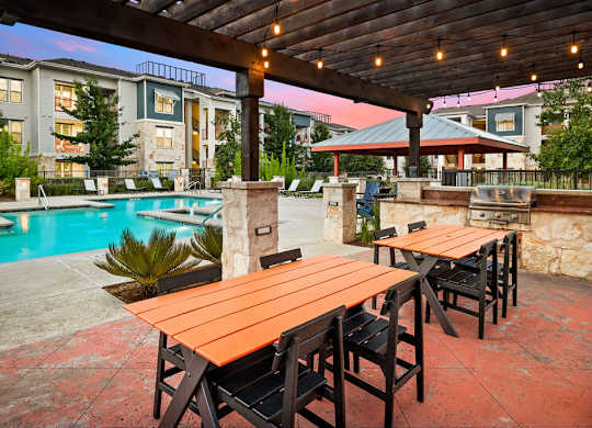 an outdoor patio with tables and a swimming pool