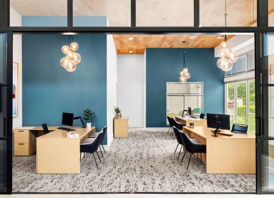 a large office with desks and chairs and a blue wall