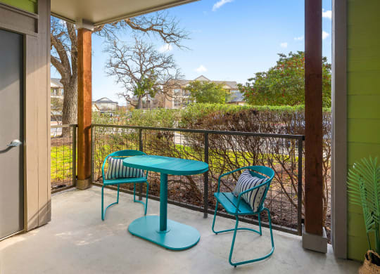 patio with beautiful view of oak trees and. teal table and chairs for relaxing.