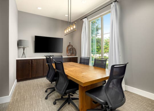 a conference room with a wooden table and chairs and a tv