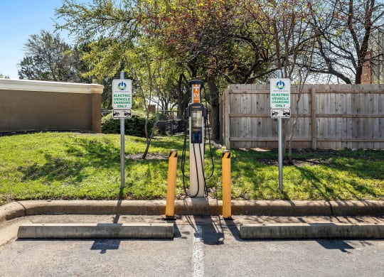 a gas station in a parking lot in front of a fence