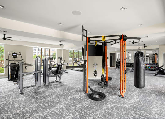 a gym with weights and cardio equipment in a building with windows