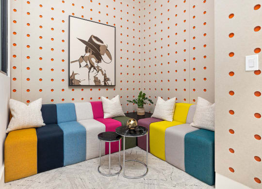 a living room with colorful couches and a painting on the wall
