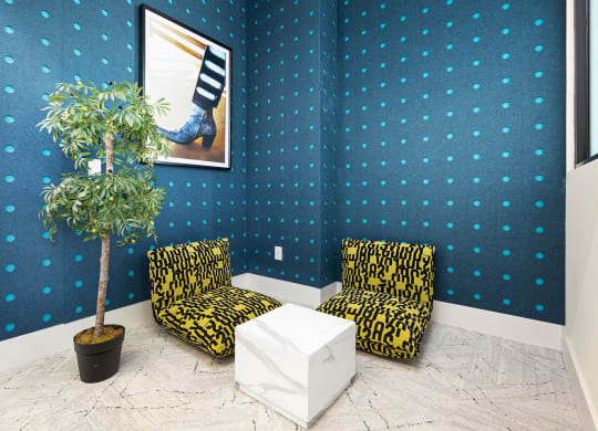 two chairs and a table in a room with a plant